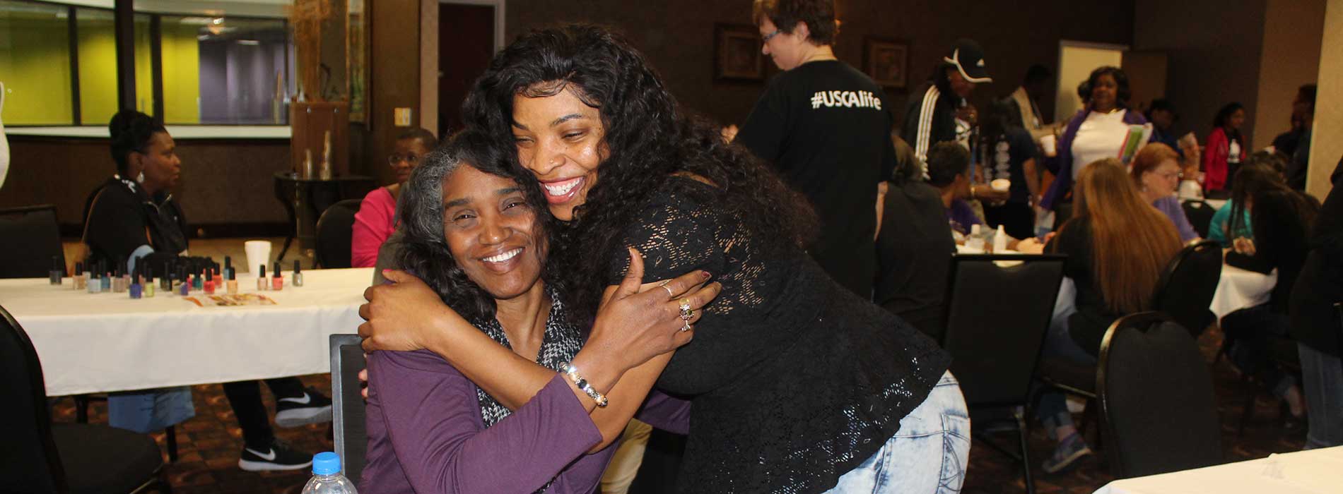 two ladies hugging at convention